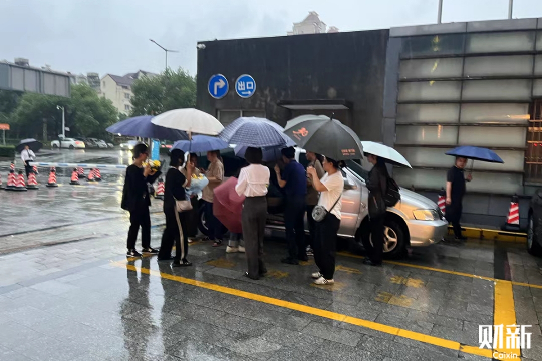 Residents lay flowers at the bus stop of the Xindi Center on Friday in Suzhou, East China’s Zhejiang province. Photo: Bao Zhimin/Caixin