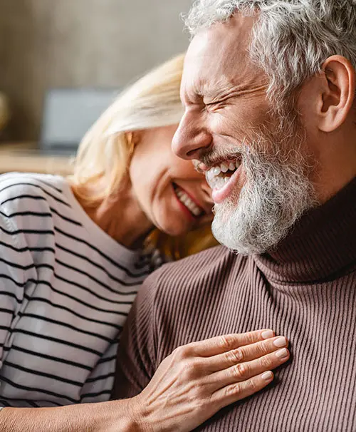 Couple smiling with hand on chest
