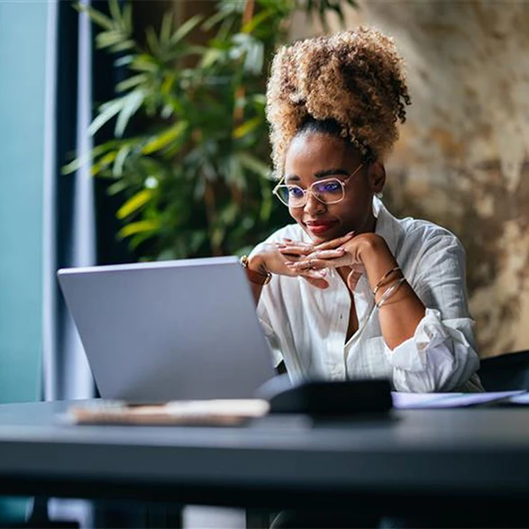 Woman looking at her laptop smiling